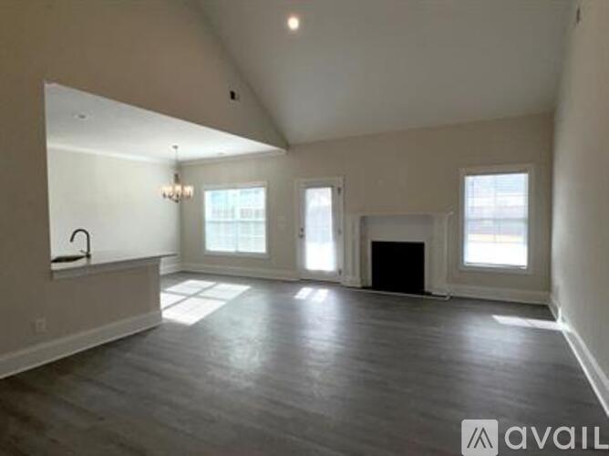 A spacious living room with a fireplace and large windows.