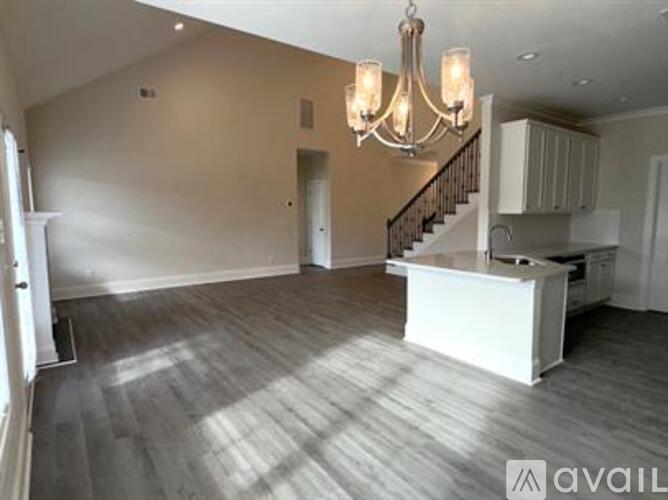 A spacious room with a white reception desk and a chandelier hanging from the ceiling.