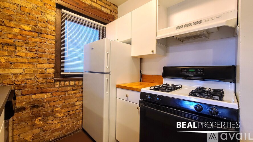 A kitchen with a black stove top oven and a white refrigerator.