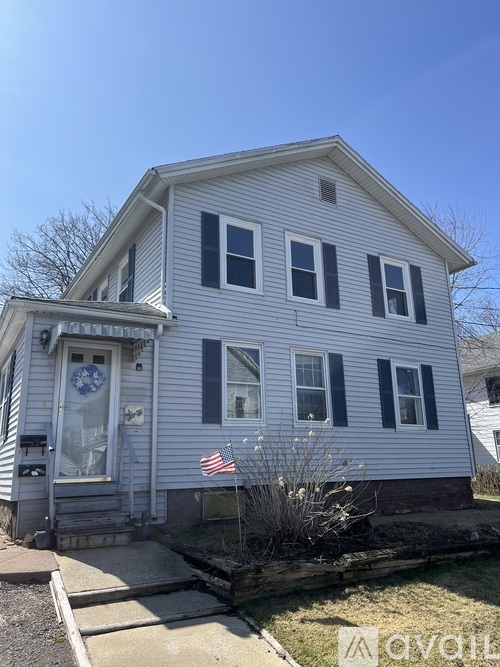 A house with a grey siding and a white door with a glass window.