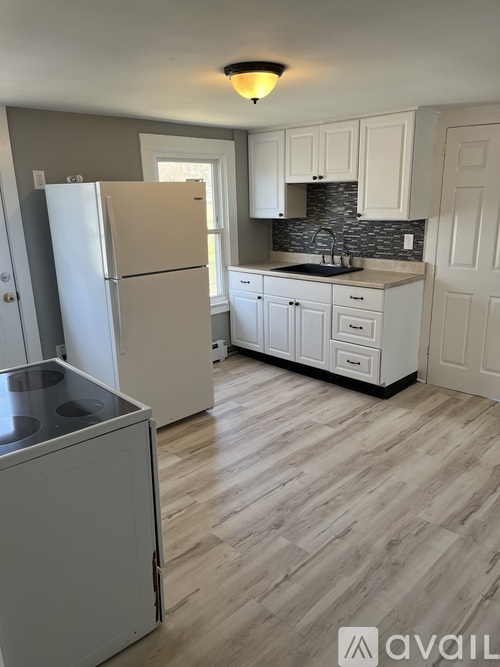 A kitchen with a white fridge and cabinets.
