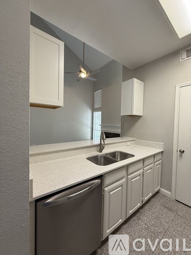 A kitchen with white cabinets and a stainless steel dishwasher.