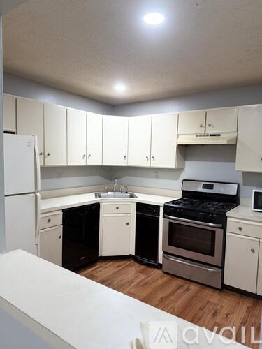 A kitchen with white cabinets and appliances.