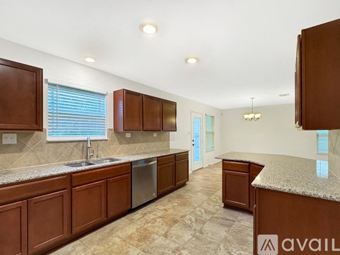 A kitchen with brown cabinets and a granite countertop.