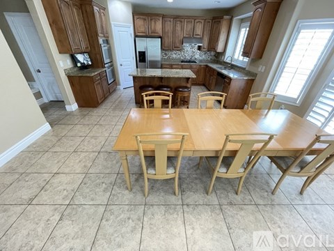A kitchen with a table and chairs in the middle of the room.