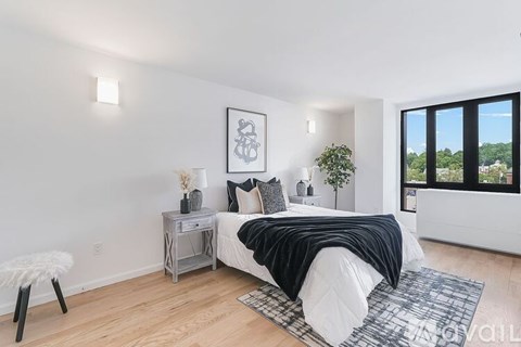 A bedroom with a bed, nightstand, and chair.