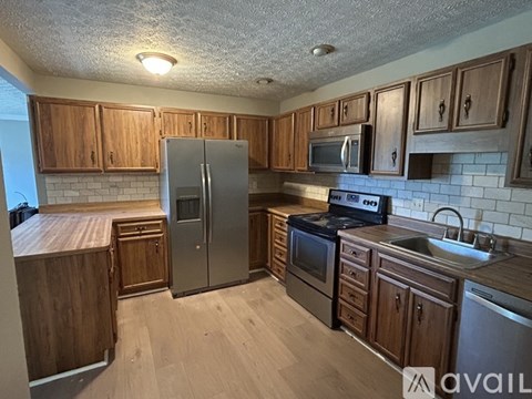 A kitchen with wooden cabinets and a refrigerator.