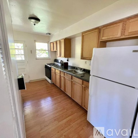 A kitchen with wooden cabinets and a white refrigerator.