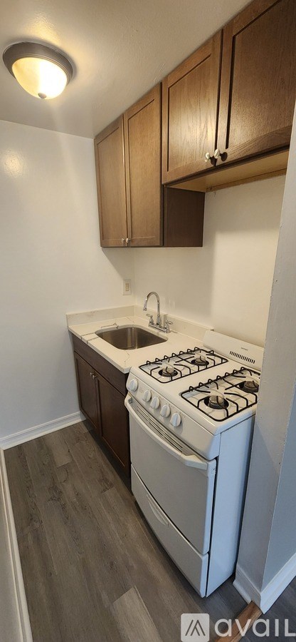 A kitchen with a white stove and wooden cabinets.