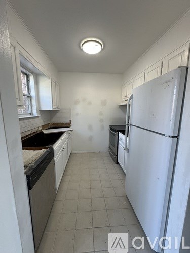A kitchen with white appliances and cabinets.