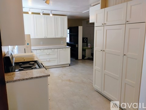 A kitchen with white cabinets and a countertop.