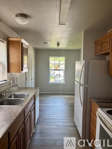 A kitchen with wooden cabinets and a white refrigerator.