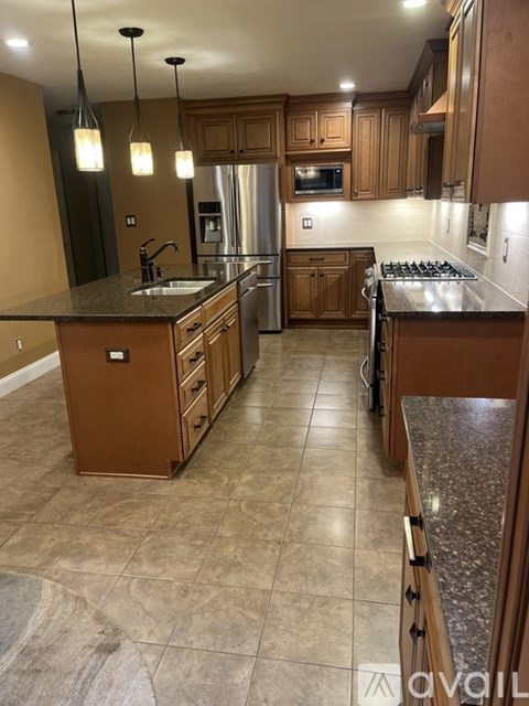 A kitchen with wooden cabinets and a granite countertop.