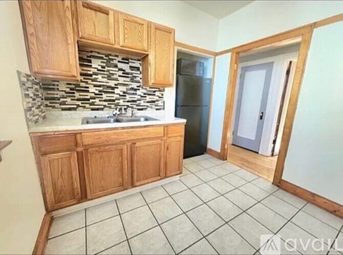 A kitchen with wooden cabinets and a tiled backsplash.