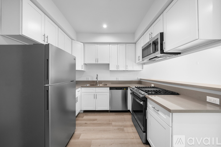 A modern kitchen with a refrigerator, microwave, and oven.