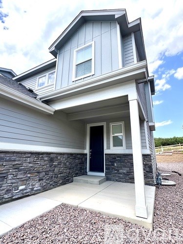 A house with a grey exterior and a dark blue door.