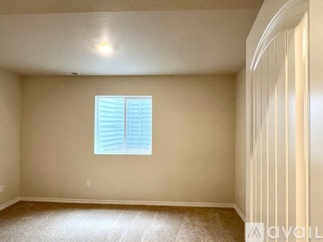 A room with a window and a carpeted floor.
