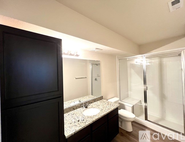 A bathroom with a sink, toilet, and mirror.