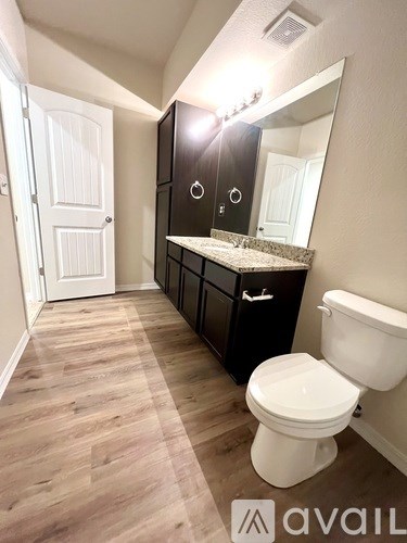 A bathroom with a toilet, sink, and medicine cabinet.