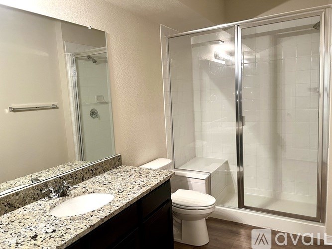 A bathroom with a sink, toilet, and shower.