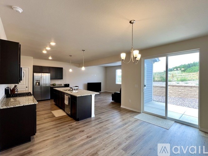 A modern kitchen with dark wood cabinets and a granite countertop.
