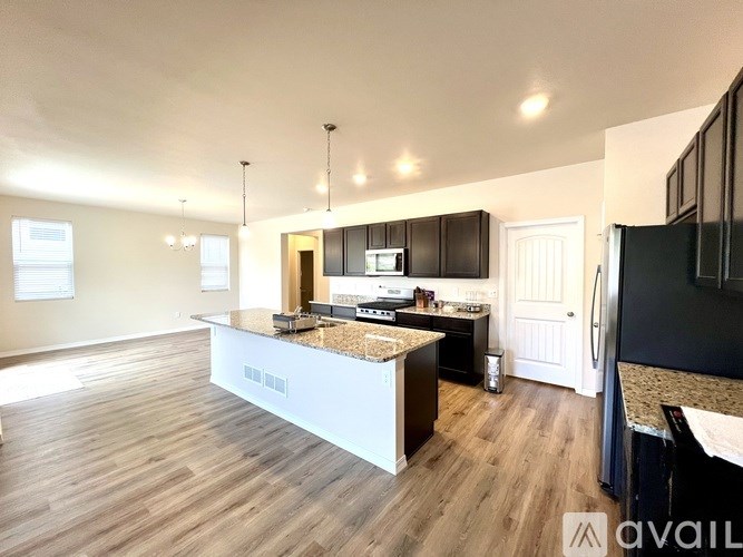 A modern kitchen with a central island and dark wood cabinets.