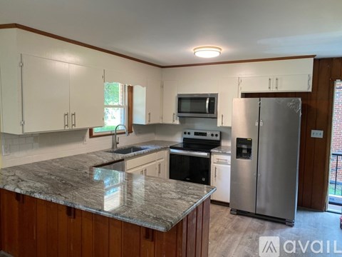 A kitchen with a granite countertop and stainless steel appliances.