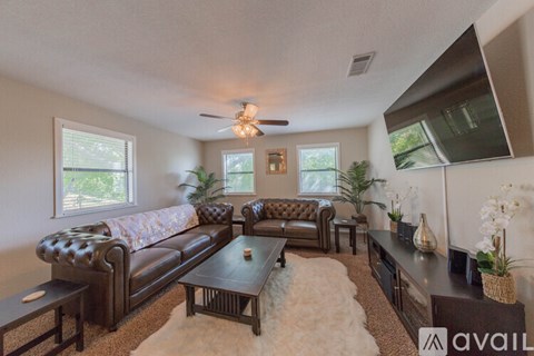 A living room with a brown leather couch and a coffee table.