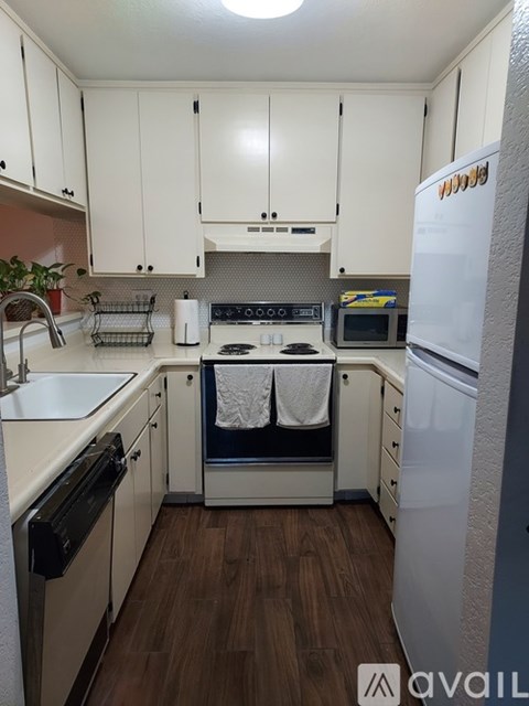 A kitchen with white cabinets and a white fridge.