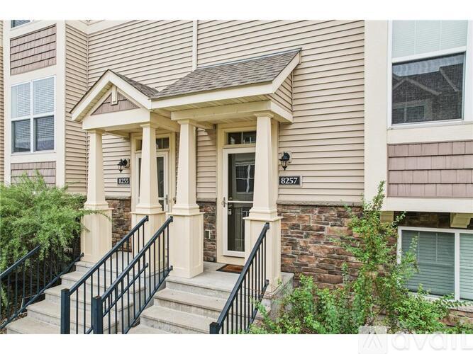 A house with a front porch and a black railing.