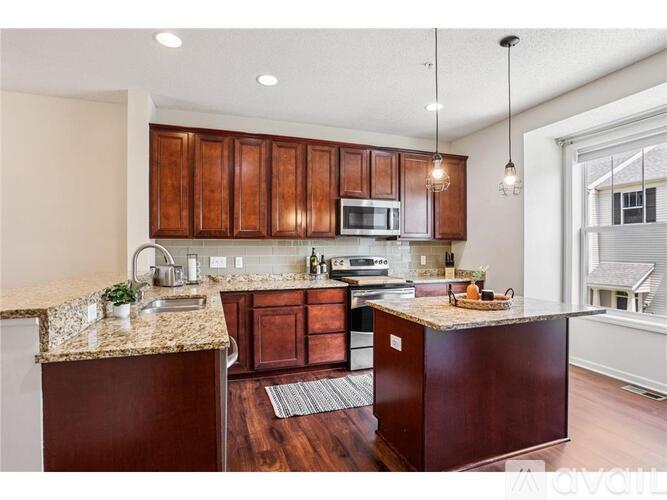 A kitchen with brown cabinets and a granite countertop.