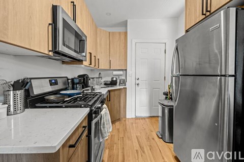 A kitchen with a stove, microwave, and refrigerator.