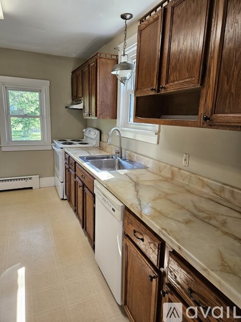 A kitchen with wooden cabinets and a marble countertop.