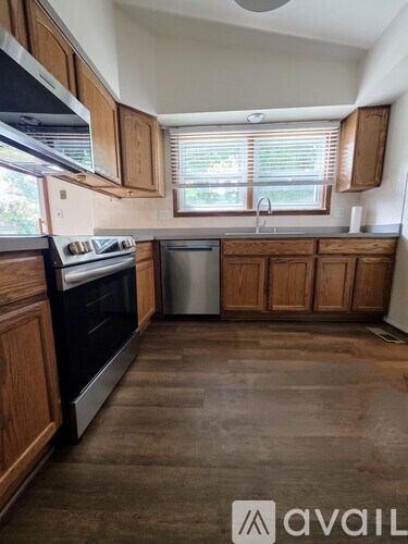 A kitchen with wooden cabinets and a stainless steel dishwasher.