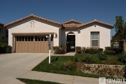 A house with a garage door and a driveway.