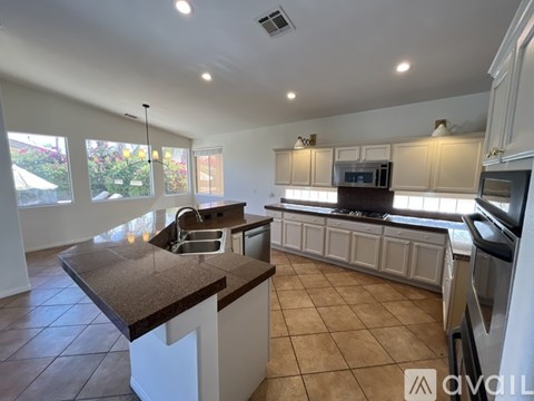 A kitchen with white cabinets and a brown countertop.