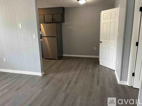A kitchen area with a refrigerator and a door.