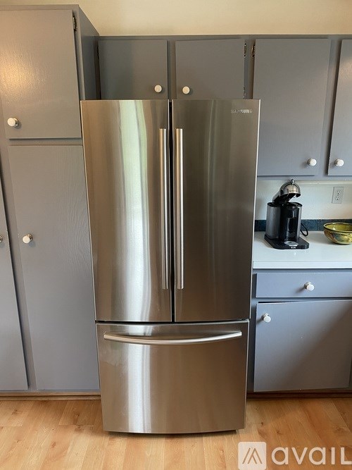 A stainless steel refrigerator with a freezer drawer is in a kitchen.