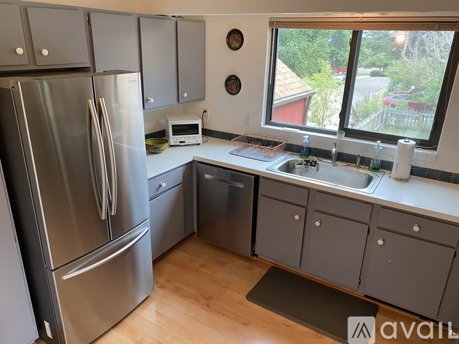 A kitchen with a stainless steel refrigerator and a dishwasher.