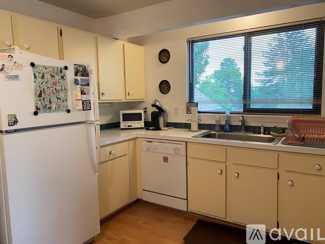 A kitchen with a white fridge, a white washing machine, and a white dishwasher.