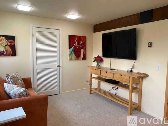 A living room with a couch, a wooden table, and a television.