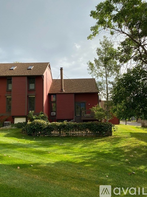 A red house with a green lawn in front.