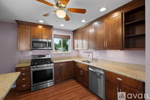 A kitchen with wooden cabinets and a ceiling fan.