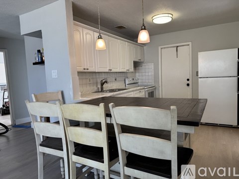 A kitchen with a table and chairs in front of it.
