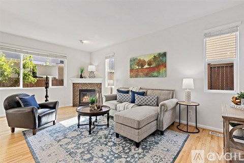 A living room with a fireplace and a painting on the wall.