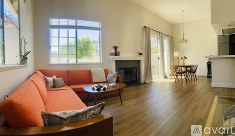 A living room with orange couches and a fireplace.