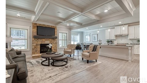 A living room with a fireplace and a television mounted above it.