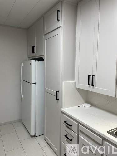 A white refrigerator and cabinets in a kitchen.