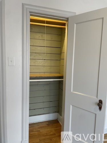 A white door with a handle and a window in the middle of the door.