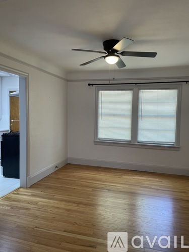 A room with a ceiling fan and wooden flooring.